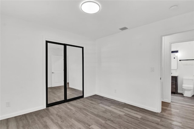 245 W George Ave, Maitland, FL 32751 - unfurnished bedroom with wood finished floors, a closet, and connected bathroom