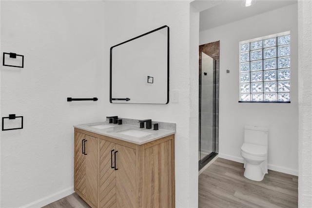 bathroom featuring walk in shower, wood-type flooring, toilet, and vanity