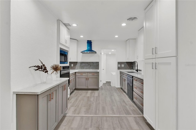 245 W George Ave, Maitland, FL 32751 - kitchen with stainless steel appliances, wall chimney exhaust hood, decorative backsplash, light wood-type flooring, and recessed lighting