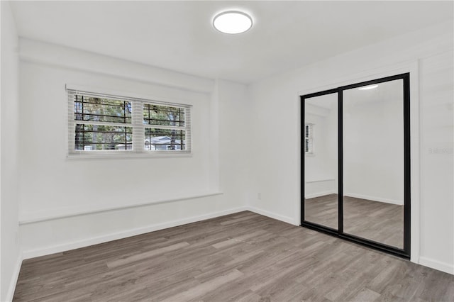 unfurnished bedroom with hardwood / wood-style flooring and a closet