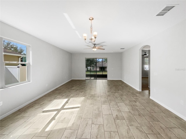 spare room with light wood-type flooring and ceiling fan with notable chandelier