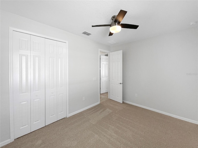 unfurnished bedroom with light carpet, ceiling fan, and a closet