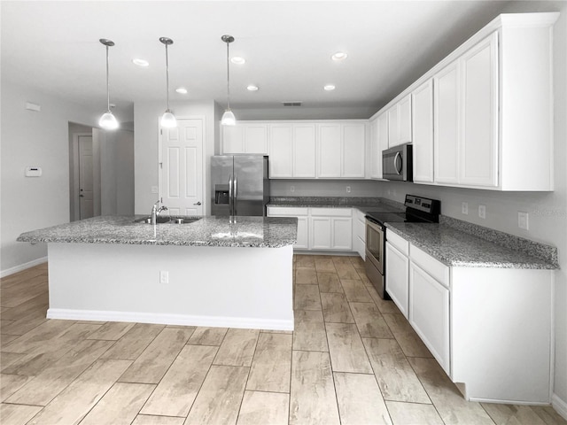 kitchen featuring sink, an island with sink, white cabinetry, appliances with stainless steel finishes, and decorative light fixtures