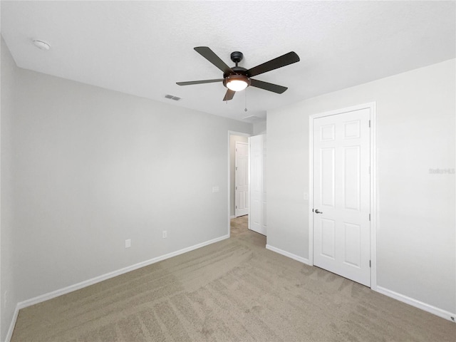 unfurnished bedroom featuring ceiling fan and light carpet