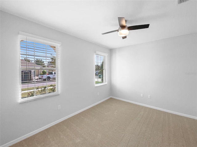 carpeted empty room with plenty of natural light and ceiling fan