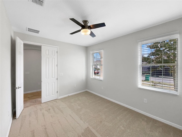 interior space featuring a closet, light colored carpet, and ceiling fan