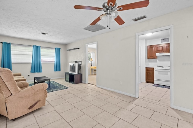 tiled living room featuring a textured ceiling and ceiling fan