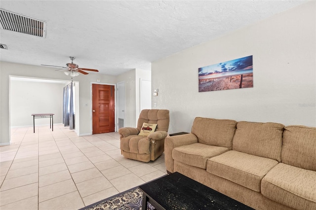 living room with a textured ceiling, light tile patterned floors, and ceiling fan