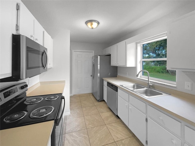 kitchen featuring stainless steel appliances, white cabinetry, sink, and light tile patterned floors