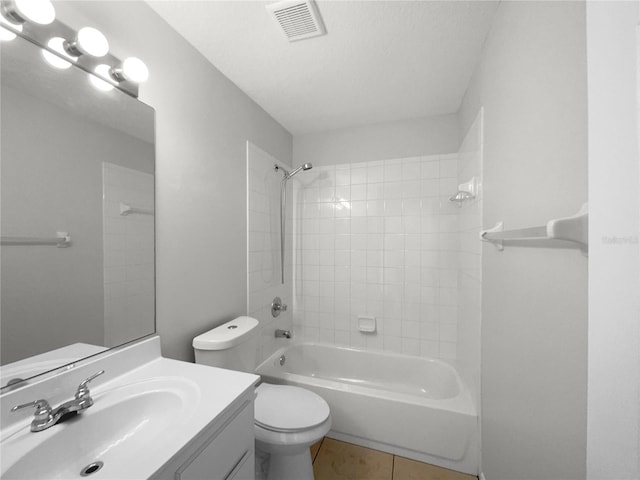 full bathroom featuring tile patterned flooring, vanity, tiled shower / bath combo, and toilet