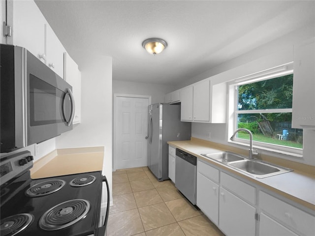 kitchen featuring white cabinetry, appliances with stainless steel finishes, sink, and light tile patterned floors