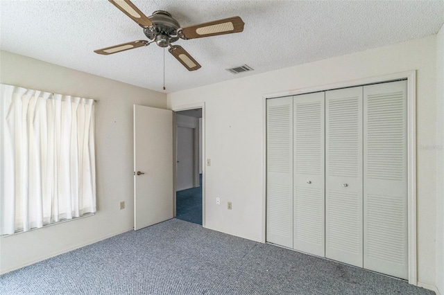 unfurnished bedroom featuring a textured ceiling, carpet floors, a closet, and ceiling fan