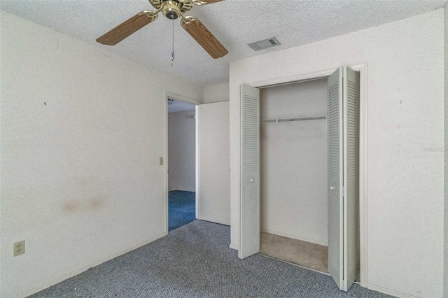 unfurnished bedroom with ceiling fan, carpet floors, a textured ceiling, and a closet