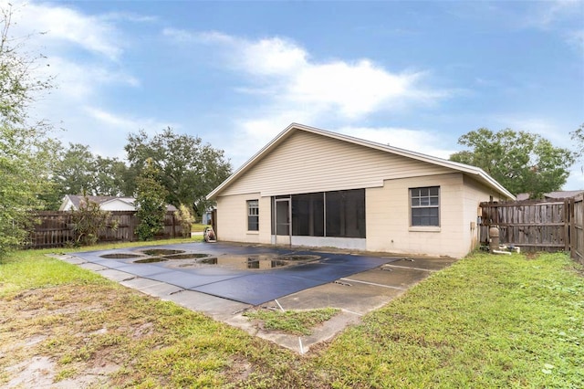 back of property with a yard and a patio