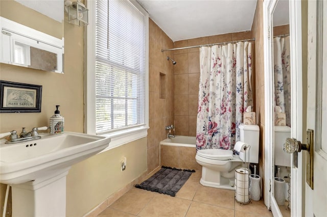 full bathroom with shower / bath combo with shower curtain, tile patterned flooring, sink, and toilet