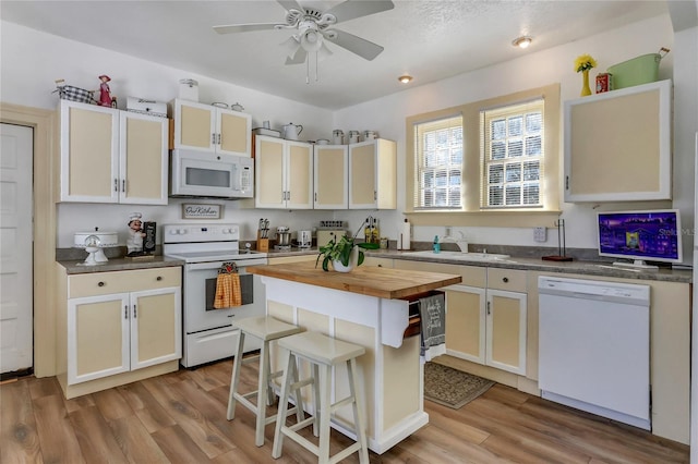 kitchen featuring wooden counters, ceiling fan, a kitchen island, light wood-type flooring, and white appliances