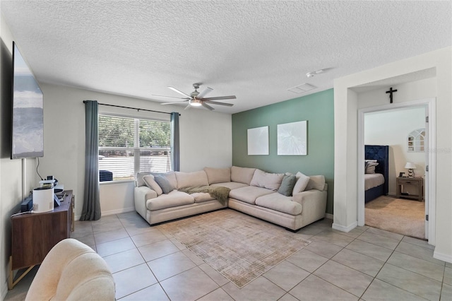 living room featuring ceiling fan, a textured ceiling, and light tile patterned flooring