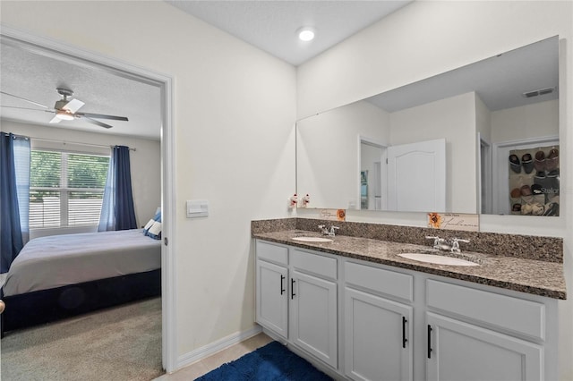 bathroom featuring vanity, ceiling fan, and a textured ceiling