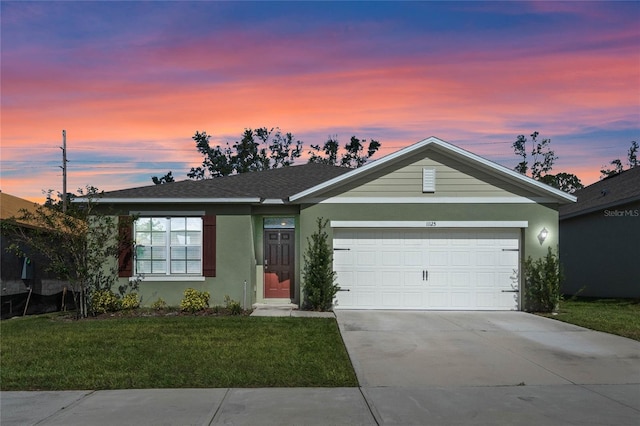 single story home with a garage and a yard