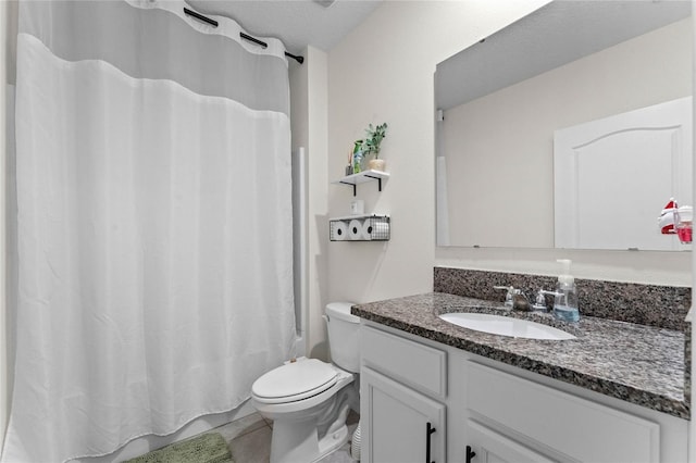 bathroom with tile patterned flooring, vanity, a textured ceiling, and toilet