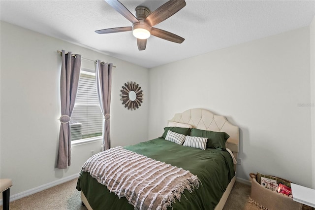 carpeted bedroom with ceiling fan and a textured ceiling