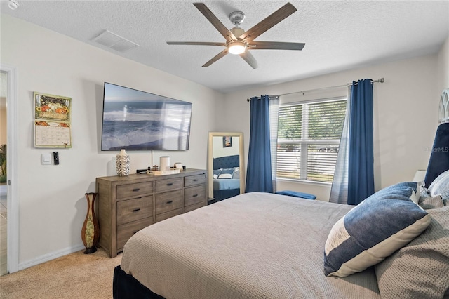 carpeted bedroom featuring ceiling fan and a textured ceiling