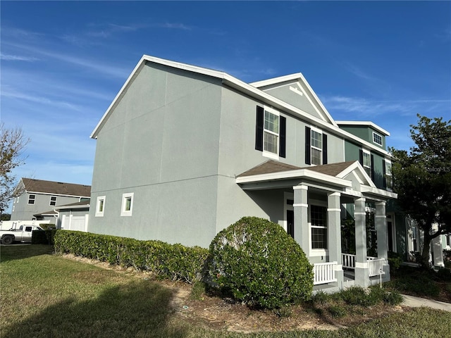 view of side of property with a lawn and covered porch