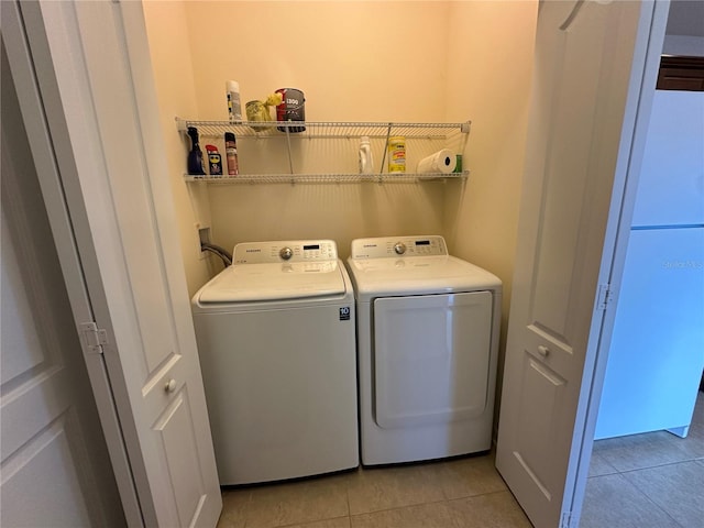 laundry room featuring light tile patterned flooring and washing machine and clothes dryer