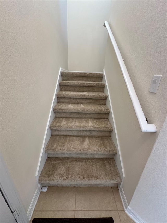 staircase featuring tile patterned flooring