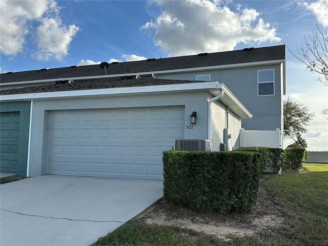 view of side of home featuring central AC and a garage