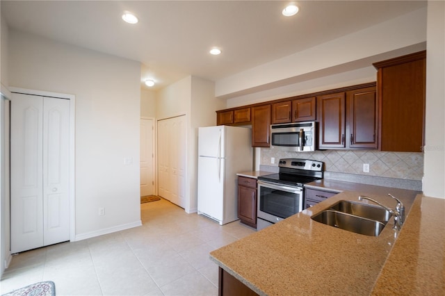 kitchen with light tile patterned floors, decorative backsplash, appliances with stainless steel finishes, a sink, and recessed lighting