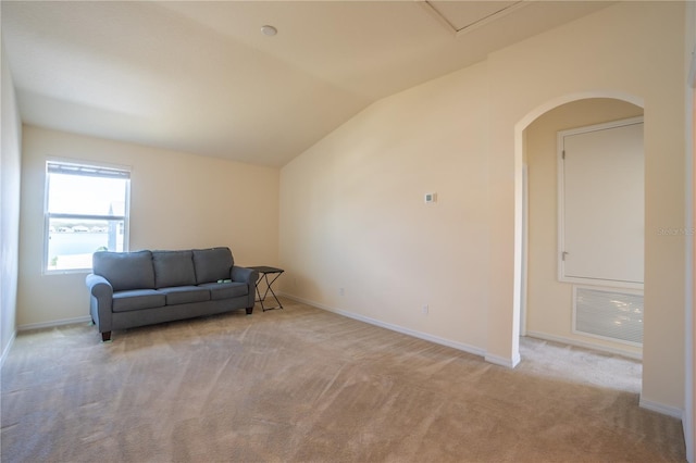 sitting room featuring baseboards, visible vents, vaulted ceiling, and light colored carpet