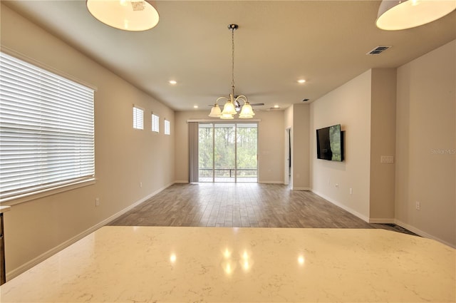 unfurnished living room featuring dark wood-type flooring and a chandelier