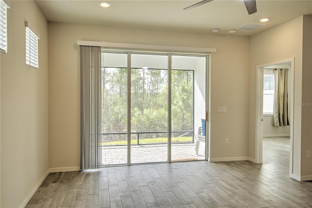 doorway with light hardwood / wood-style floors, ceiling fan, and a healthy amount of sunlight