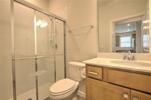 bathroom with a shower with door, vanity, and toilet