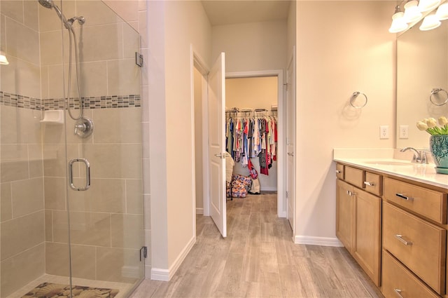 bathroom featuring walk in shower, hardwood / wood-style floors, and vanity