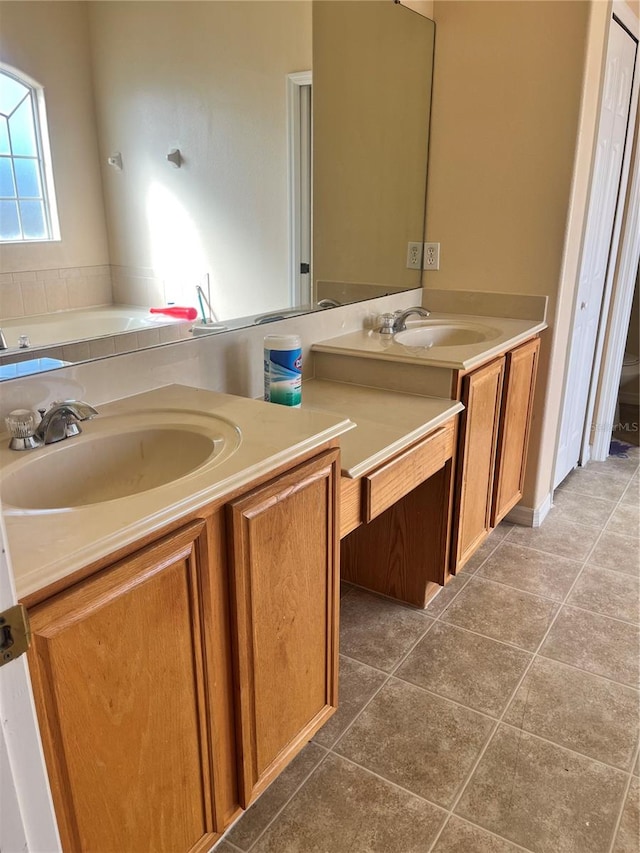 bathroom with a bathtub, vanity, and tile patterned floors