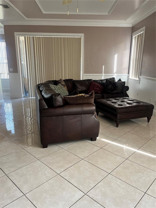 living room featuring light tile patterned floors and crown molding