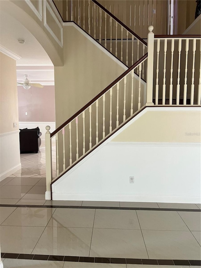 stairs featuring ceiling fan, tile patterned flooring, and crown molding