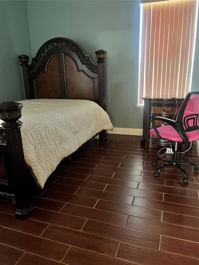 bedroom with dark hardwood / wood-style flooring