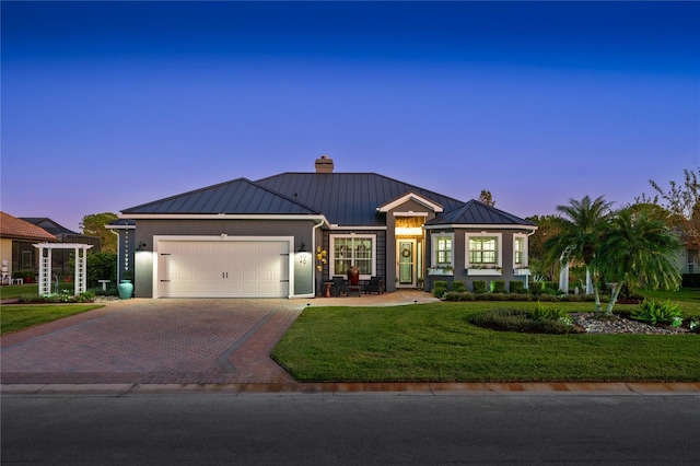 view of front of house featuring a garage and a lawn