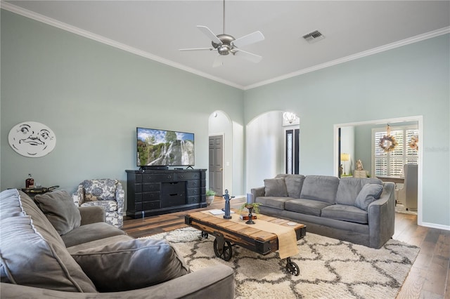 living room featuring a high ceiling, hardwood / wood-style flooring, ceiling fan, and crown molding