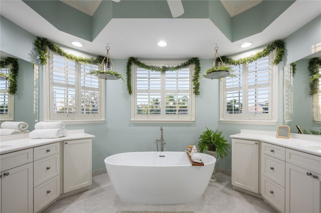 bathroom with a bathing tub, plenty of natural light, vanity, and ornamental molding