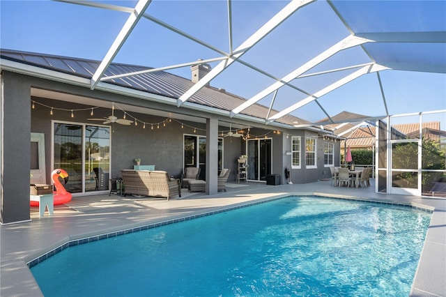 rear view of property with glass enclosure, ceiling fan, outdoor lounge area, and a patio