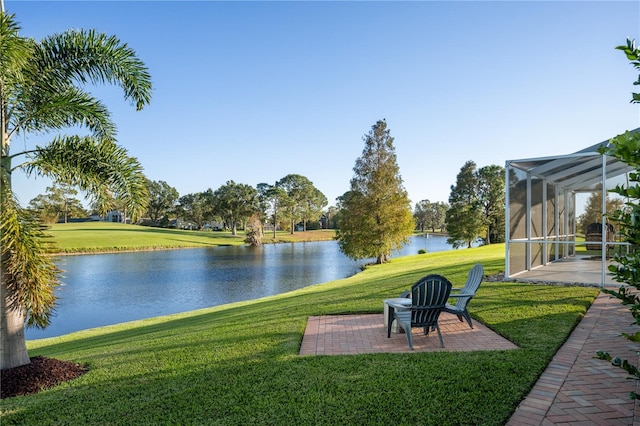 view of yard with a lanai, a patio area, and a water view