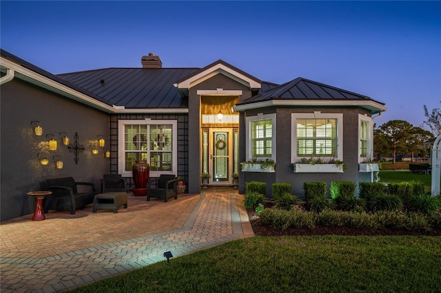 view of front facade with a lawn and a patio