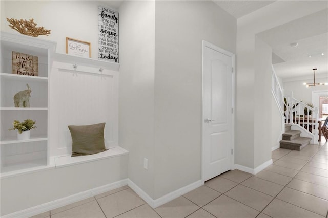 mudroom with light tile patterned floors and a notable chandelier