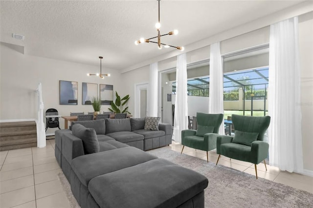 living room featuring a textured ceiling, a chandelier, and light tile patterned flooring