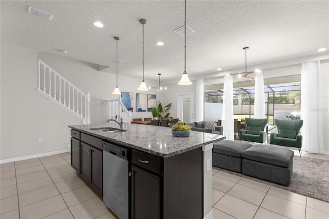 kitchen with sink, a textured ceiling, an island with sink, hanging light fixtures, and dishwasher