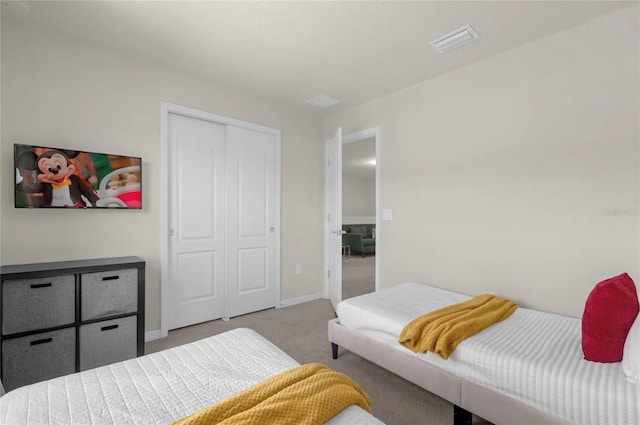 bedroom with light colored carpet and a closet